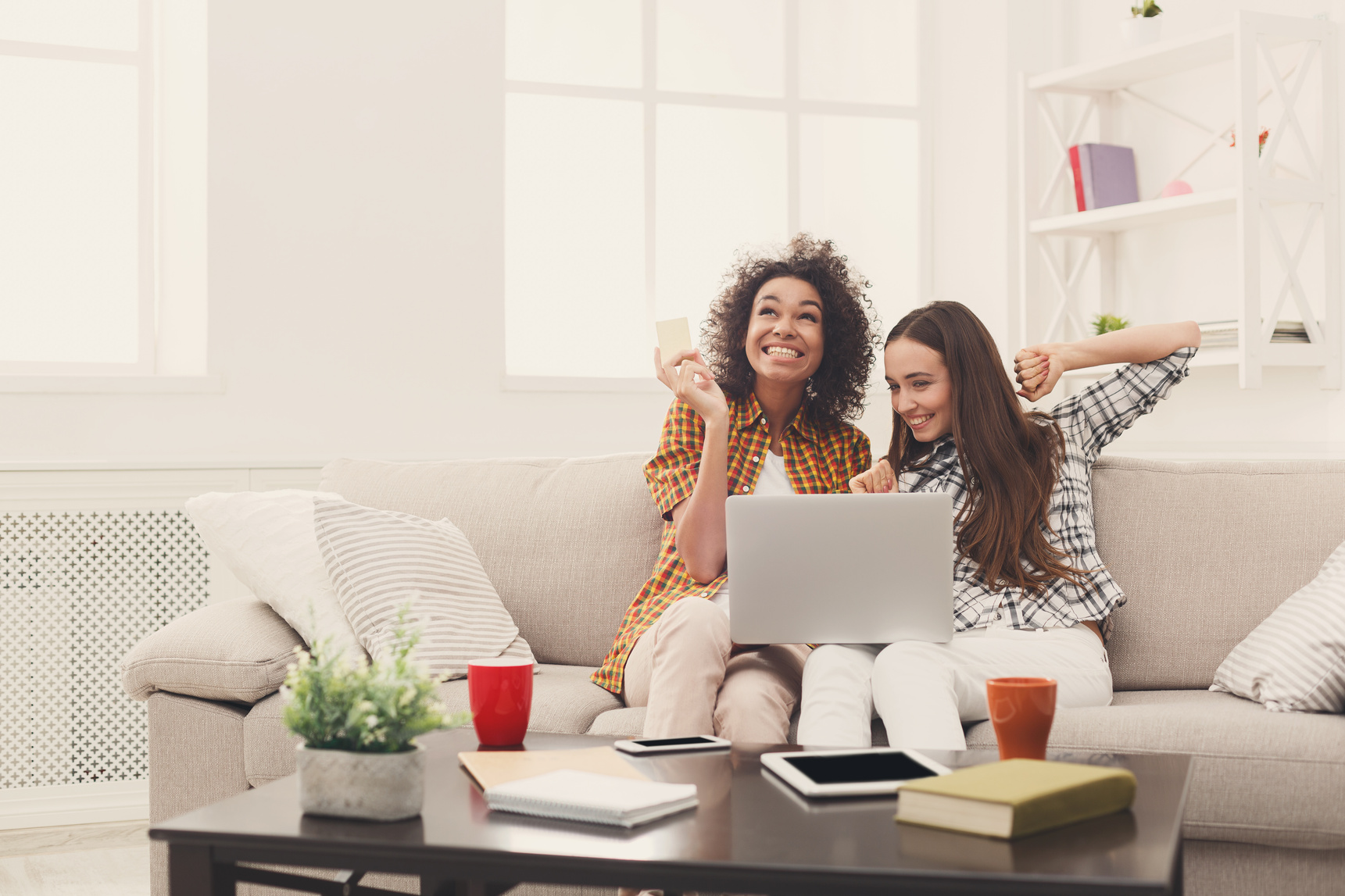 Two women online with credit card and laptop
